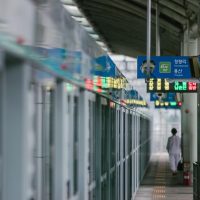 长春地图公共交通编辑何砚舟在地铁站台记录线路指示信息的现场照片，站内灯光明亮
